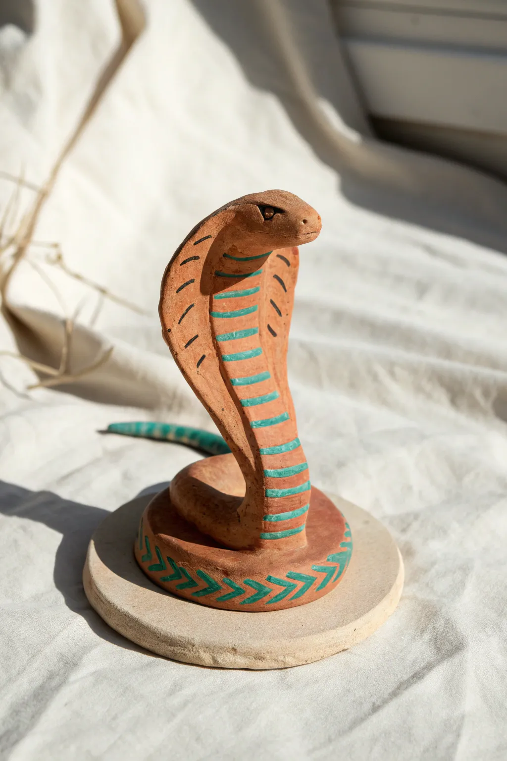 Mini hooded cobra in clay, simple lines and bold color for a striking minimalist display