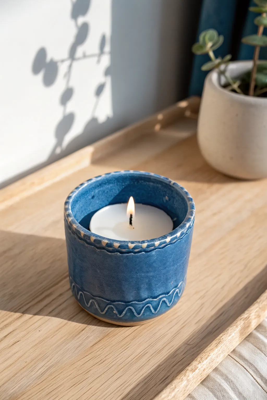 Minimalist wavy-rim clay tea light holder in matte cobalt blue for a modern, cozy glow.