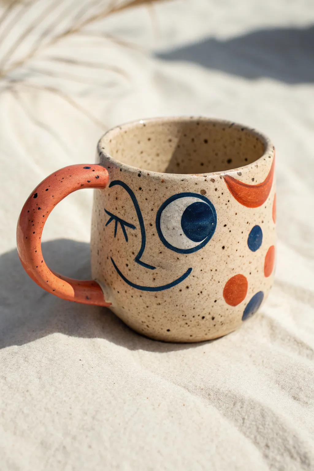 Derpy face mug with wonky grin and ear handle, bold glaze, minimalist boho styling.