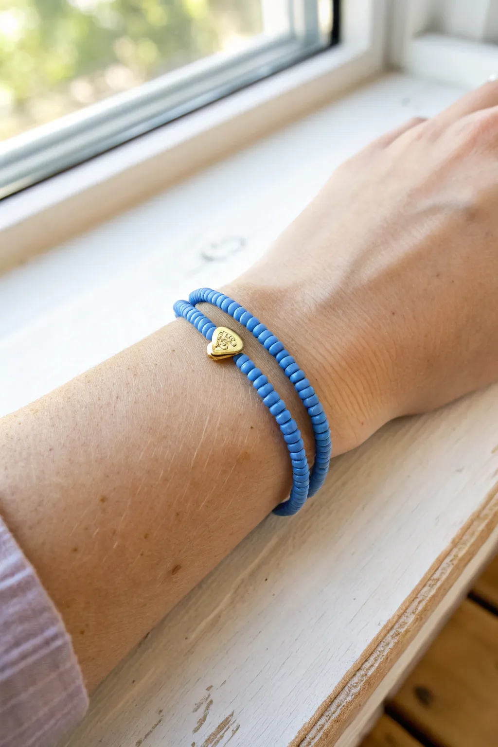 Cobalt-blue heishi beads with a tiny heart charm for an easy, sweet bracelet stack.