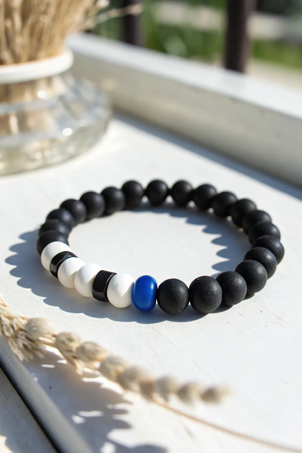 Classic black-and-white clay bead bracelet with a bold center pop for simple, chic style.