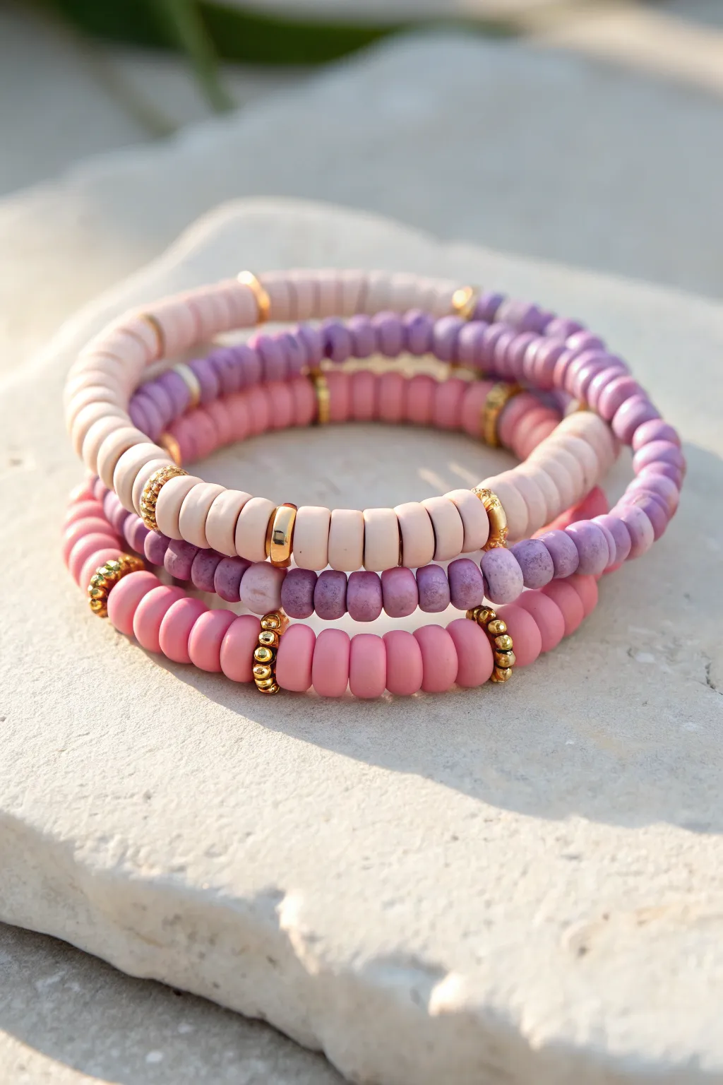 Pink and lilac sweet stack of clay bead bracelets with subtle gold spacers, bright and minimal.