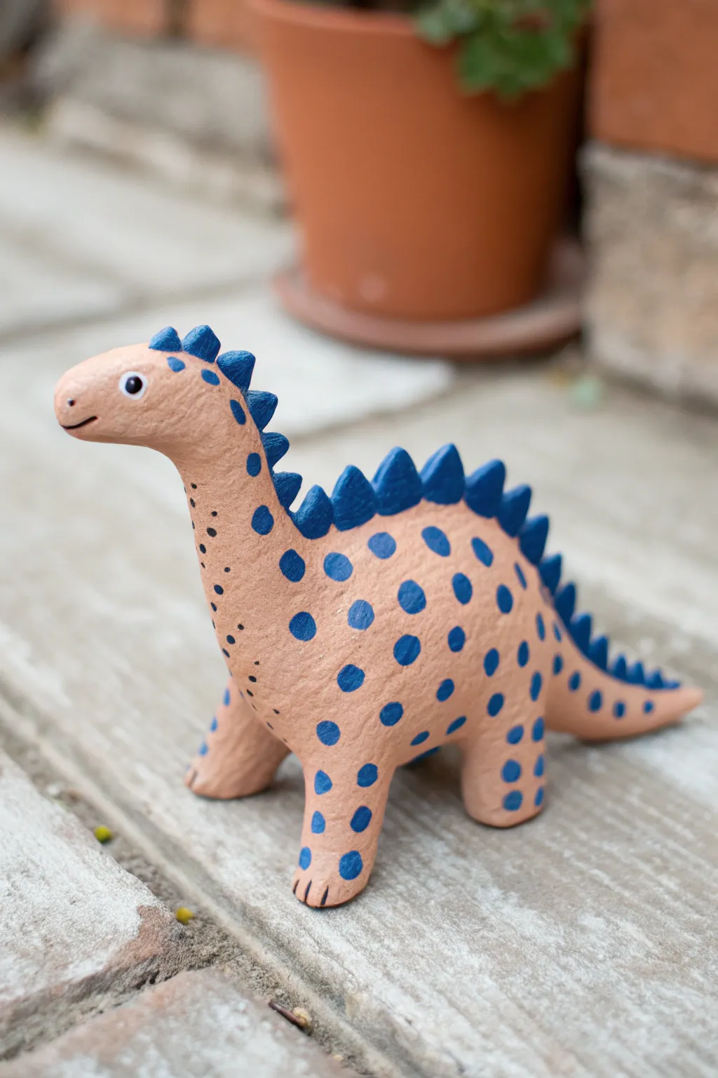 Simple spotted dot scales make this rounded clay dinosaur bold, modern, and beginner friendly