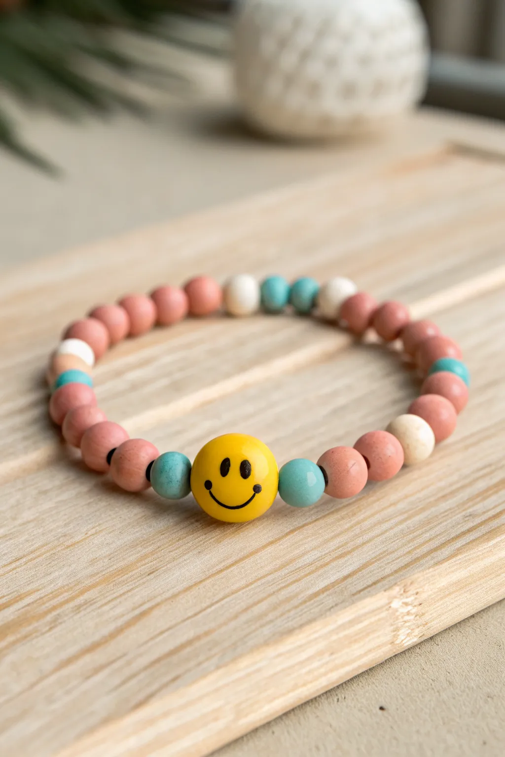 Centered smiley bead bracelet with balanced color blocks, a cheerful DIY look in modern minimal style.