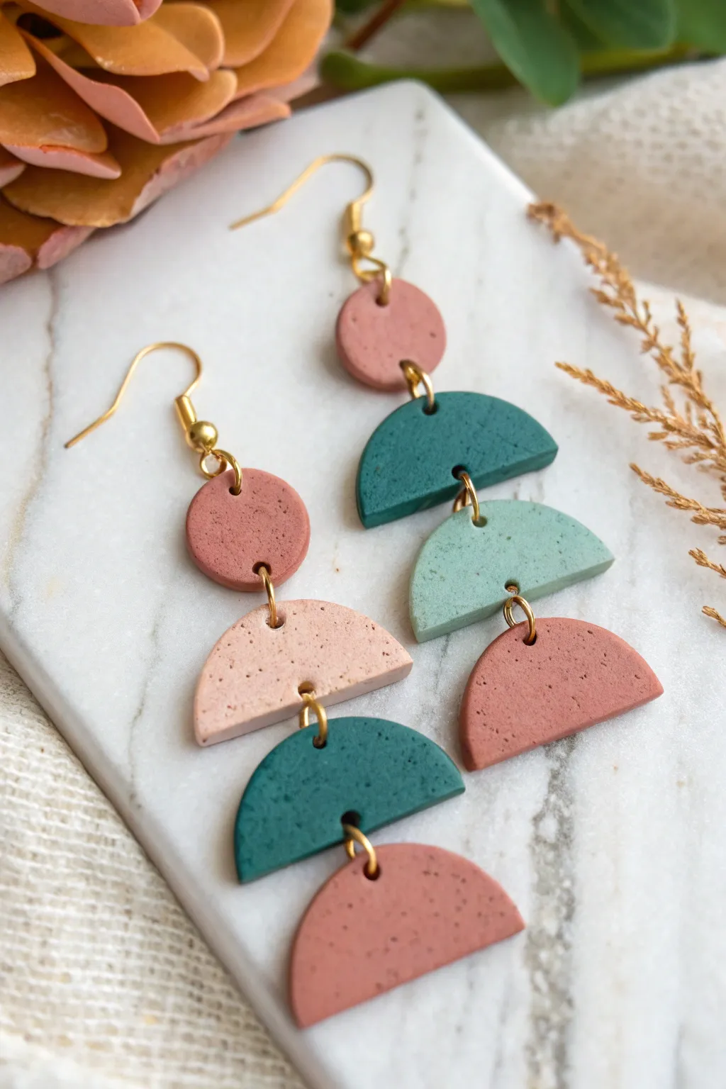 Stacked geometric clay earrings in bold tones, with visible jump rings for easy DIY layering.
