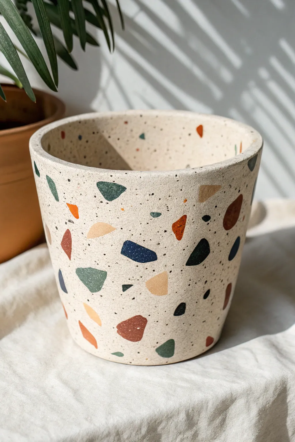 Terrazzo speckle clay pot in soft neutrals with bold chips, minimalist boho statement.