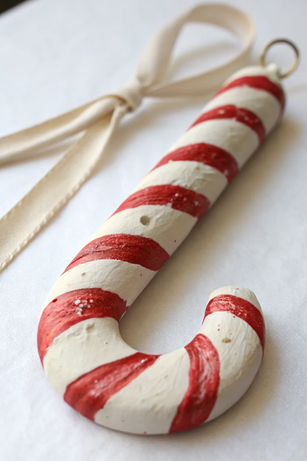 Simple candy cane clay ornament with crisp red stripes and ribbon, ready to hang and gift.