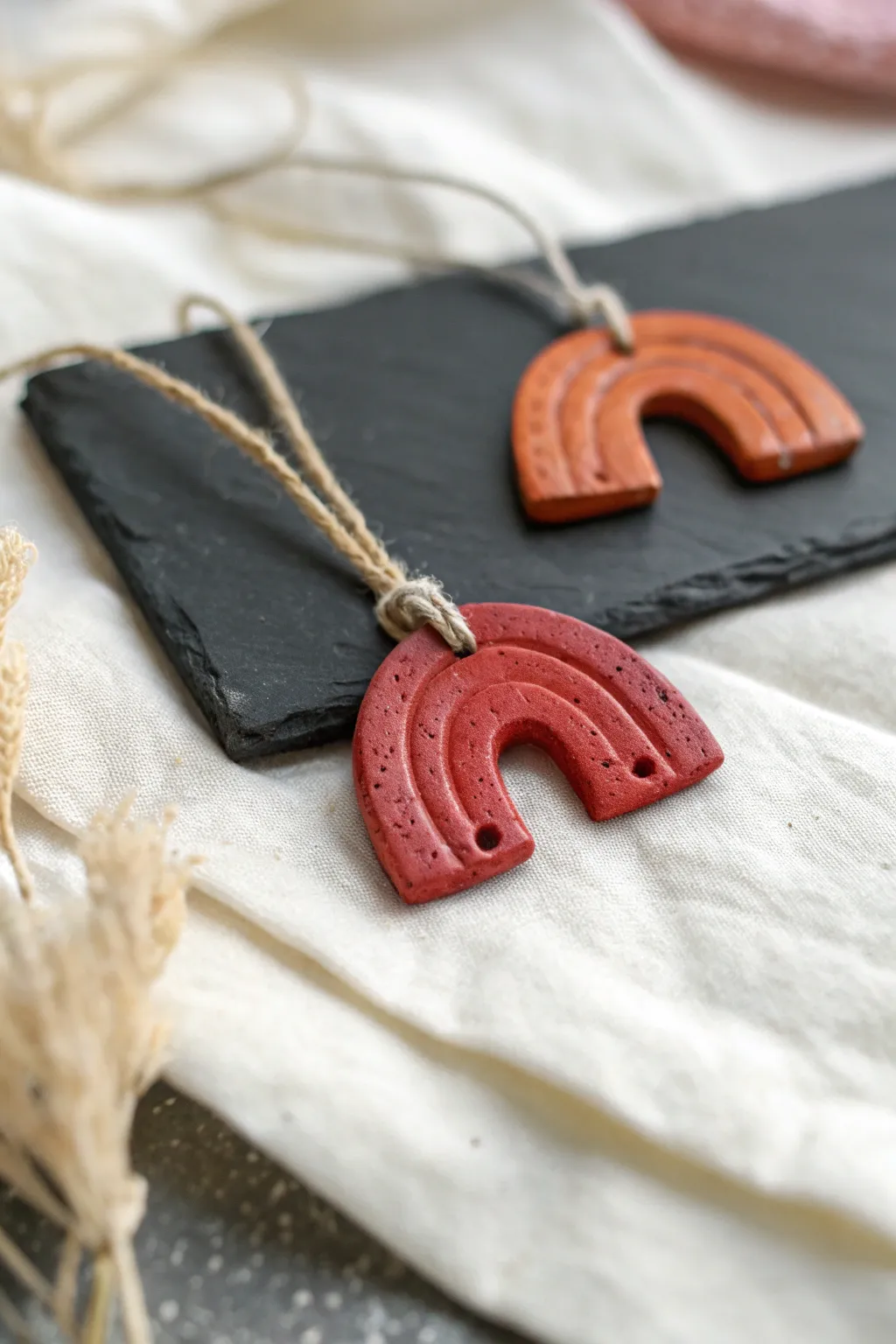 Tiny red clay pendant charms in minimalist boho style, simple shapes and bold warm color.