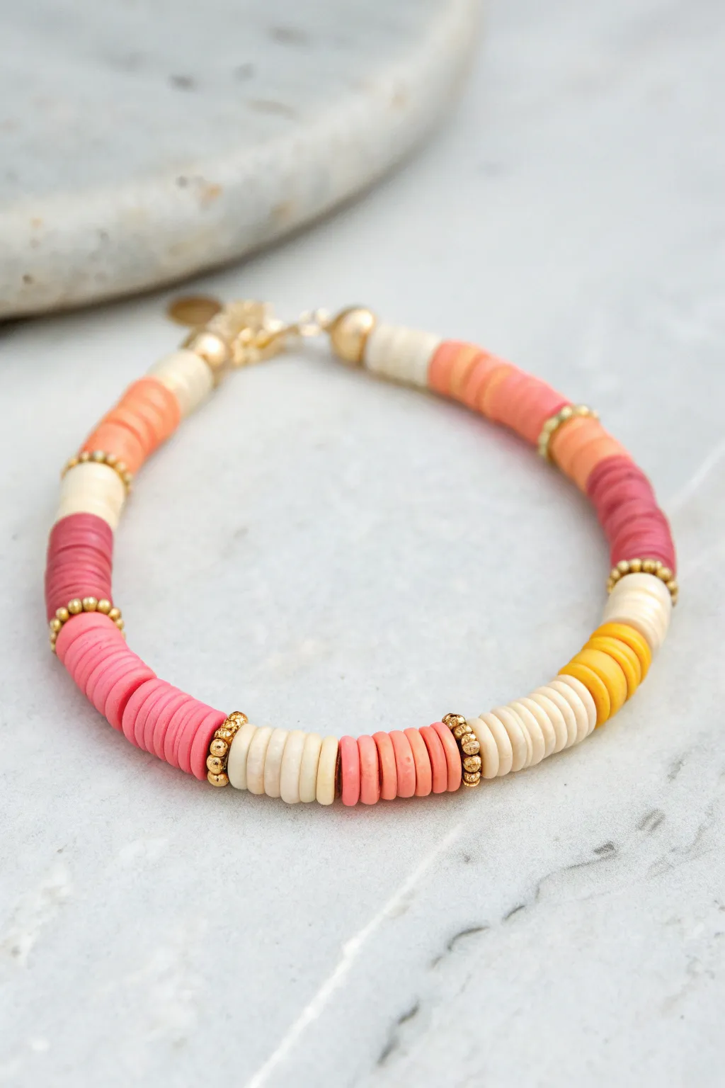 Sunset sorbet heishi bracelet in coral to yellow gradient, balanced with neutral beads.