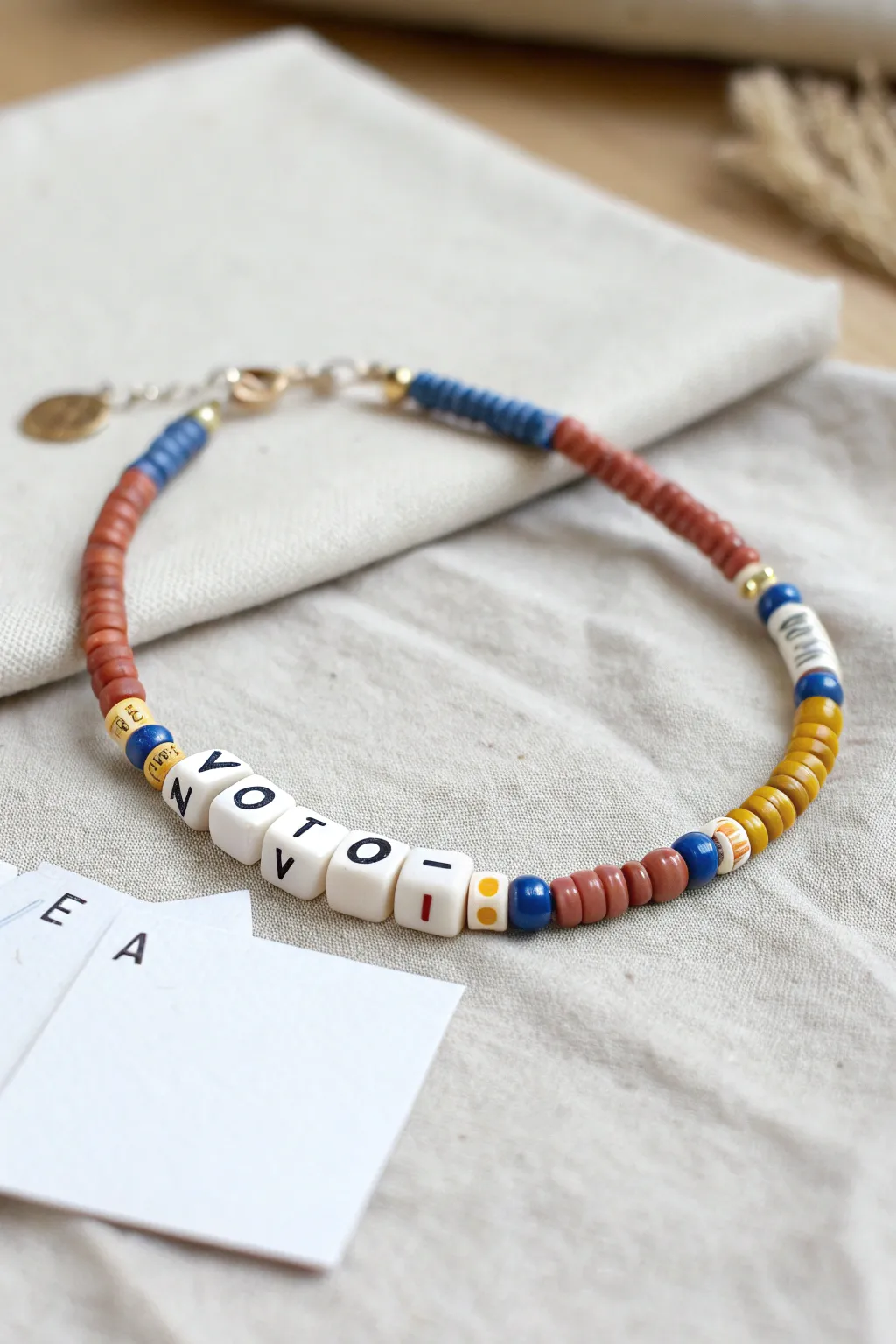 Minimal boho message bracelet with bold heishi accents, styled gift-ready beside a blank card.