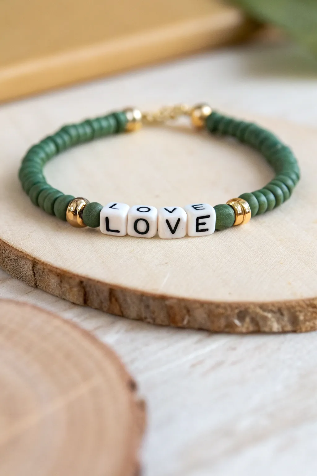 Minimal green clay heishi bracelet with a simple word center for a personal, modern boho touch.