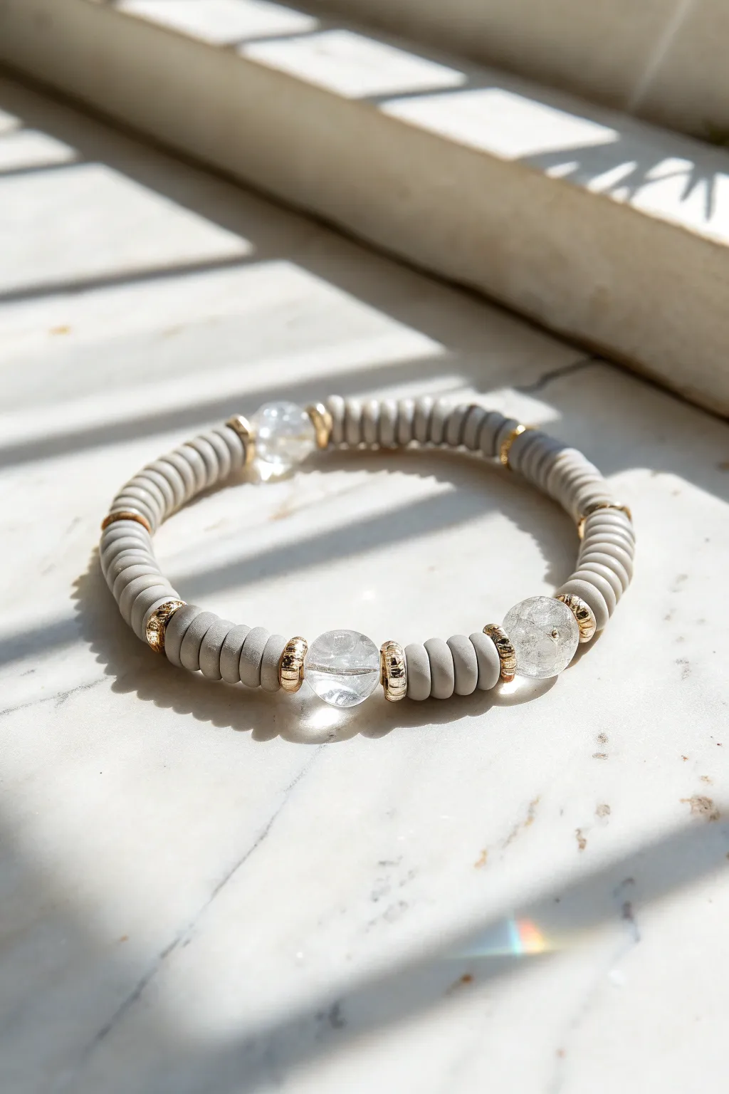 Grey clay heishi bracelet with clear faceted accents, clean Scandinavian style and soft sparkle.
