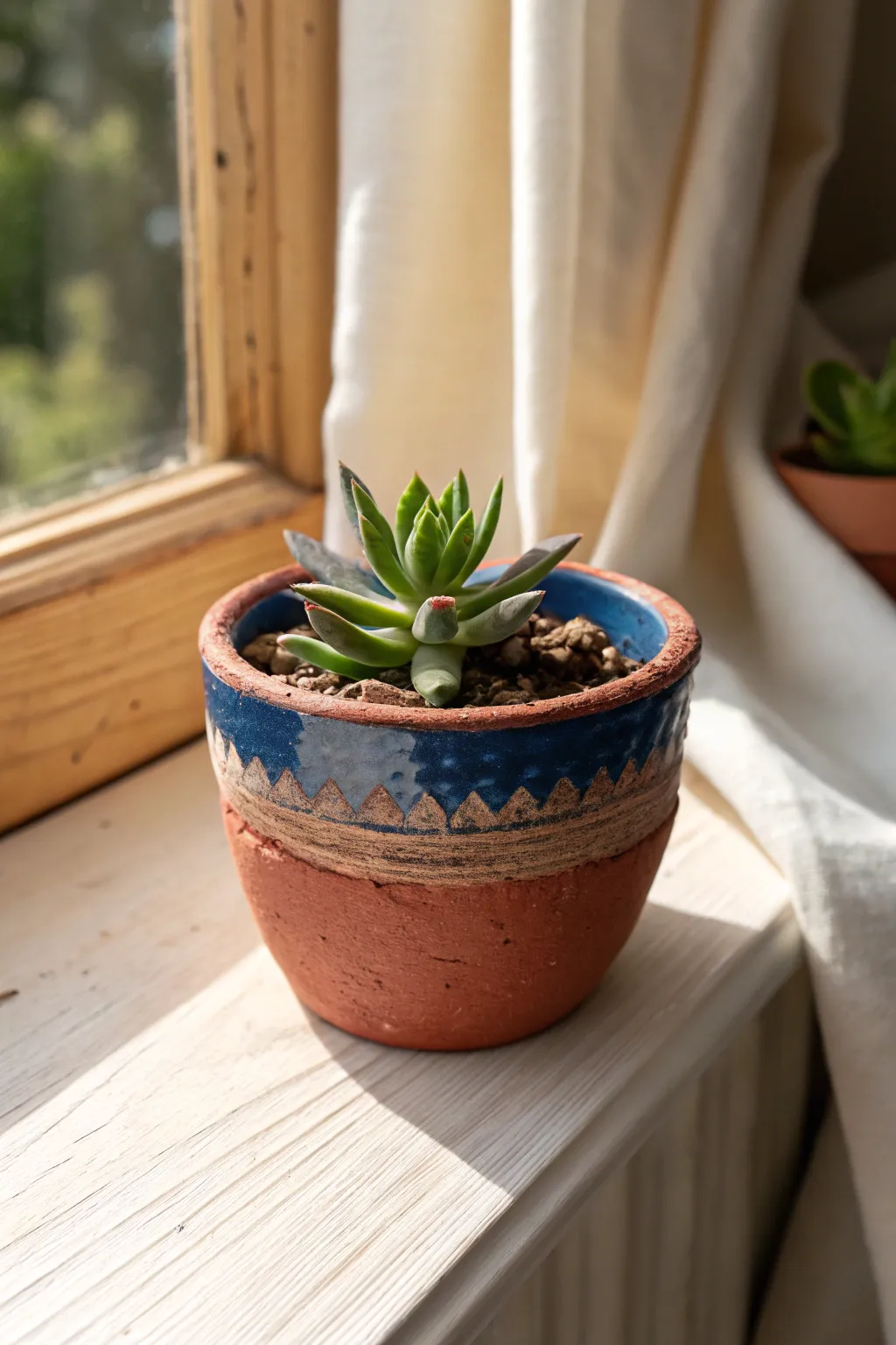 Mini pinch pot planter with a bright succulent, warm window light, and simple handmade charm