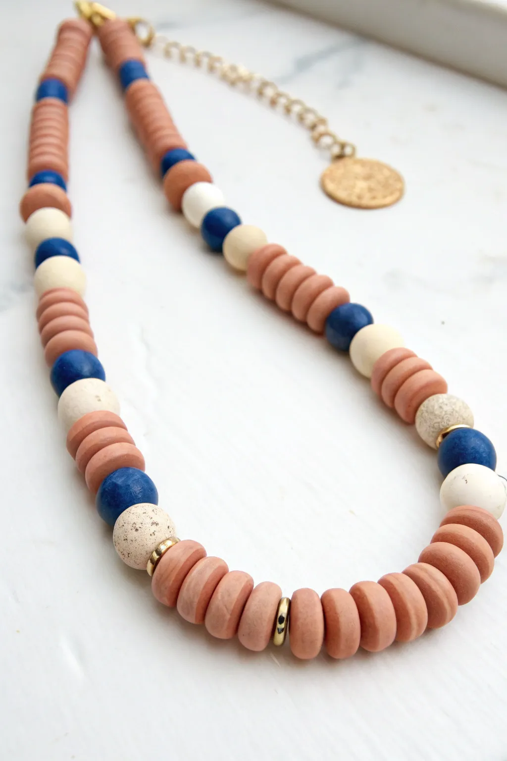 Mixed-shape oven-bake clay bead necklace in warm neutrals with a bold cobalt pop