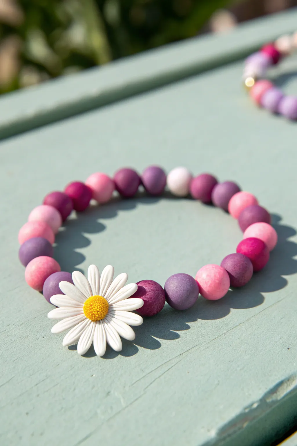 Daisy charm bracelet in vivid pink and purple clay beads, Scandinavian-boho minimalism