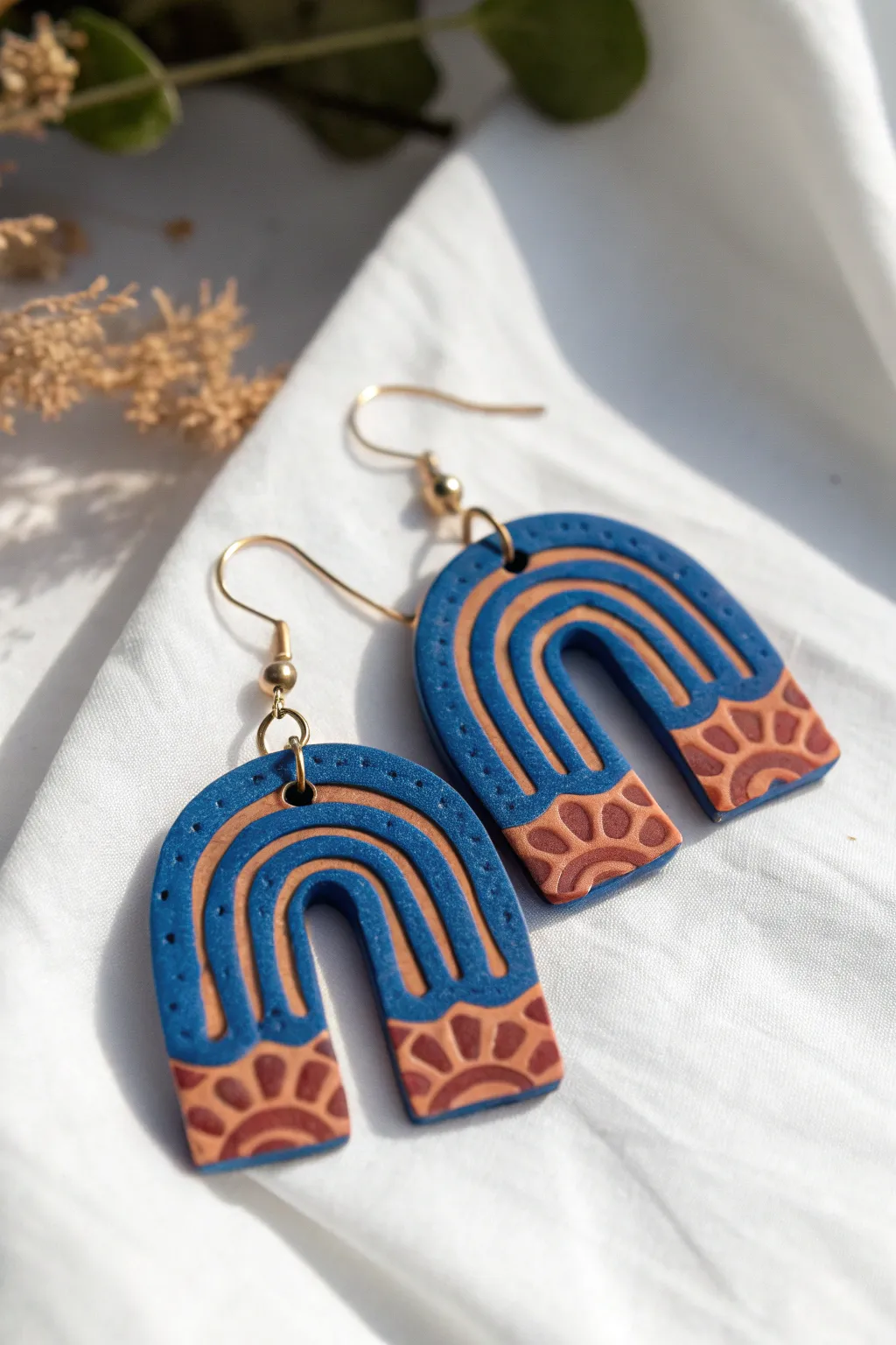 Textured imprint polymer clay earrings in bold arches, simple patterns, clean minimalist styling.