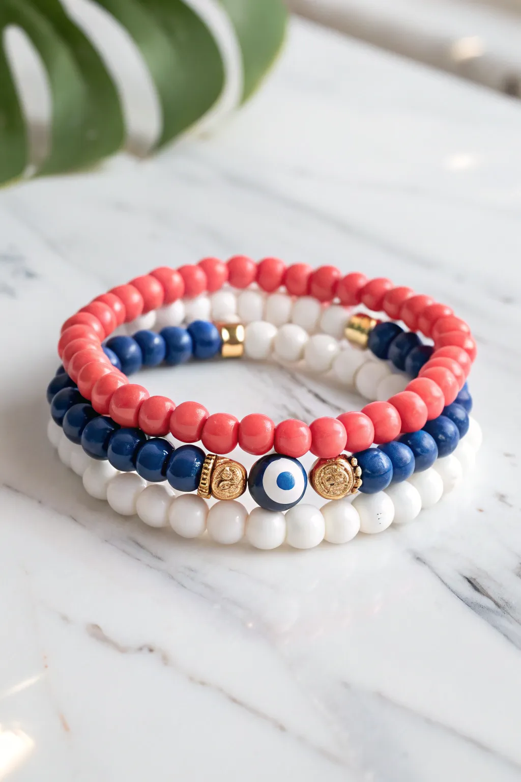 Preppy clay bead stack with a tiny evil eye and gold spacers on clean marble, Pinterest ready
