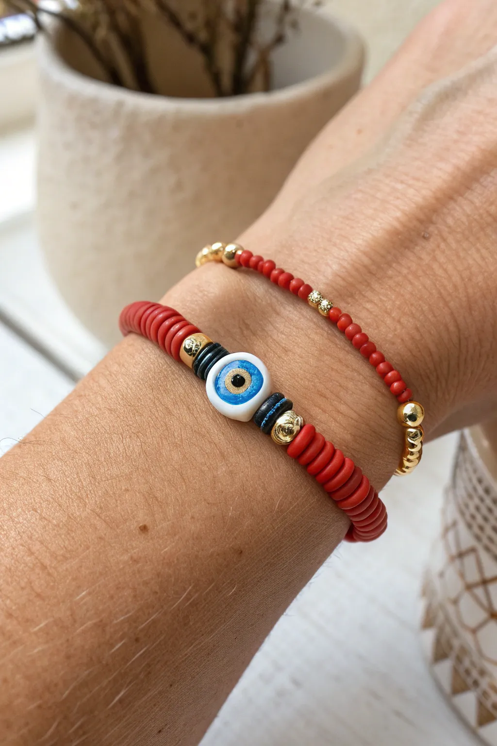 Red heishi bracelet with a protective eye focal bead, minimal yet bold and boho chic.