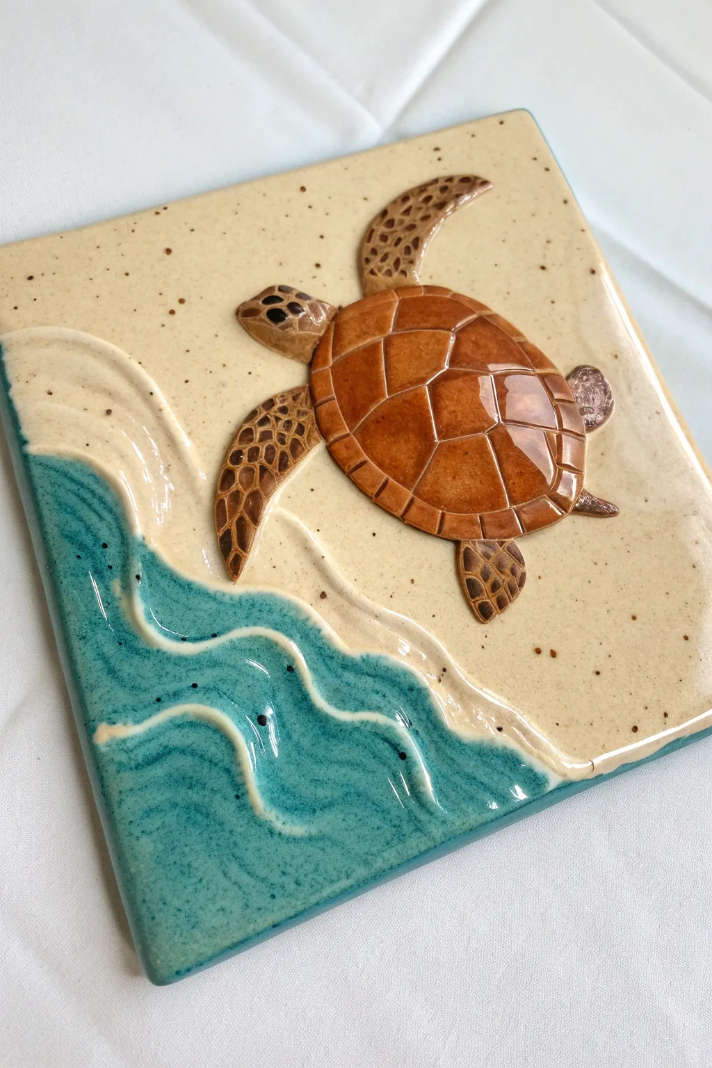 Layered sea turtle relief tile with glossy teal waves and matte sand for calm coastal contrast.