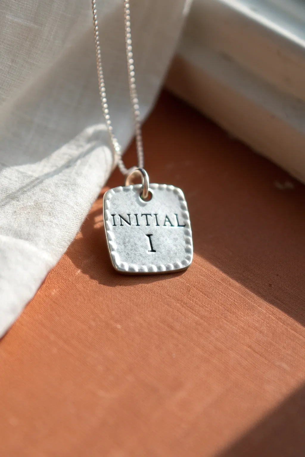 Simple silver clay initial charm with handmade texture, a chic minimalist necklace idea.