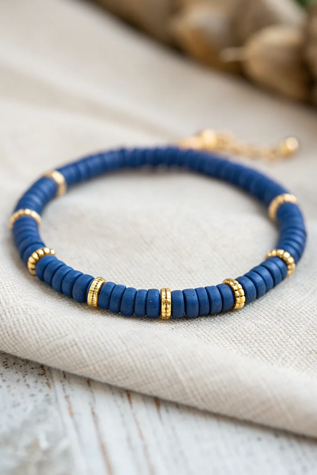 Matte clay heishi beads + gold spacers make a simple rhythmic bracelet you can DIY today.