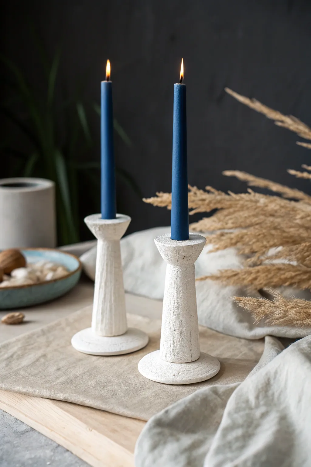 White clay taper holders with bold cobalt candles for a calm, minimalist Scandinavian vibe