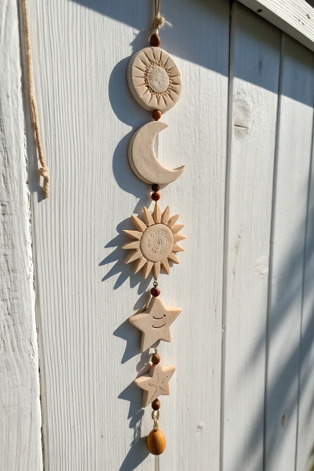 Neutral boho moon and sun air dry clay wall hanging with soft shadows and minimalist charm