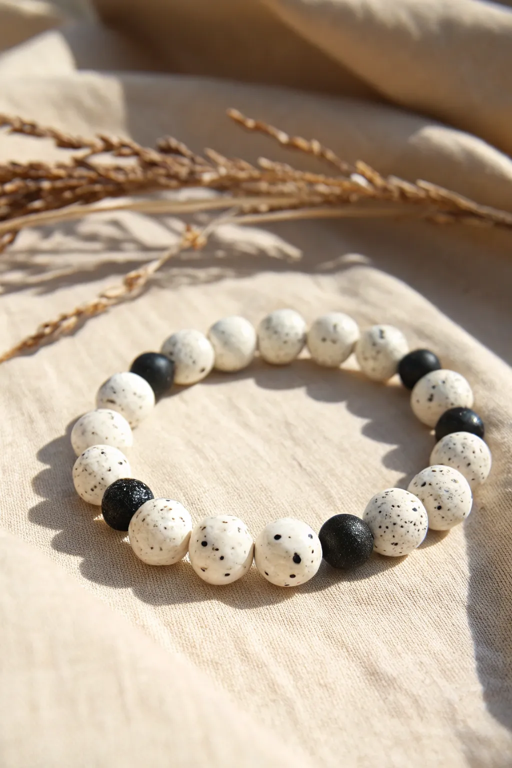 Speckled white clay beads with matte black accents for a minimalist bracelet full of texture.