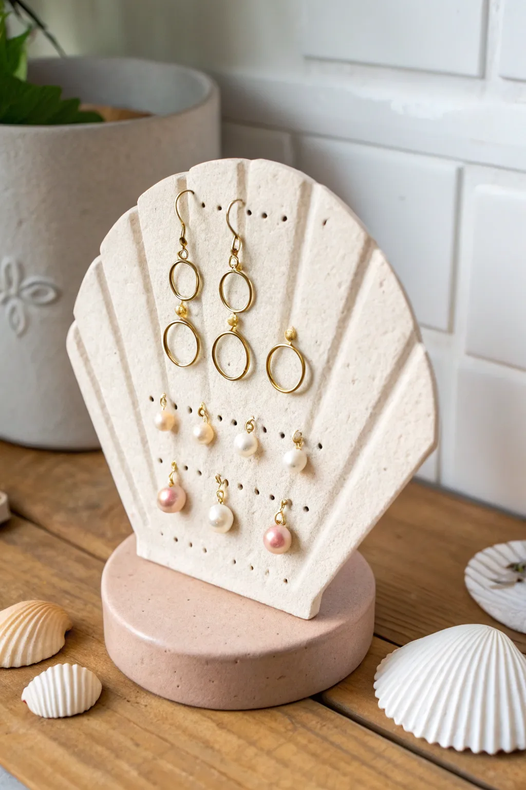 Scalloped fan earring stand with neat stud rows, soft clay tones, minimalist boho styling.