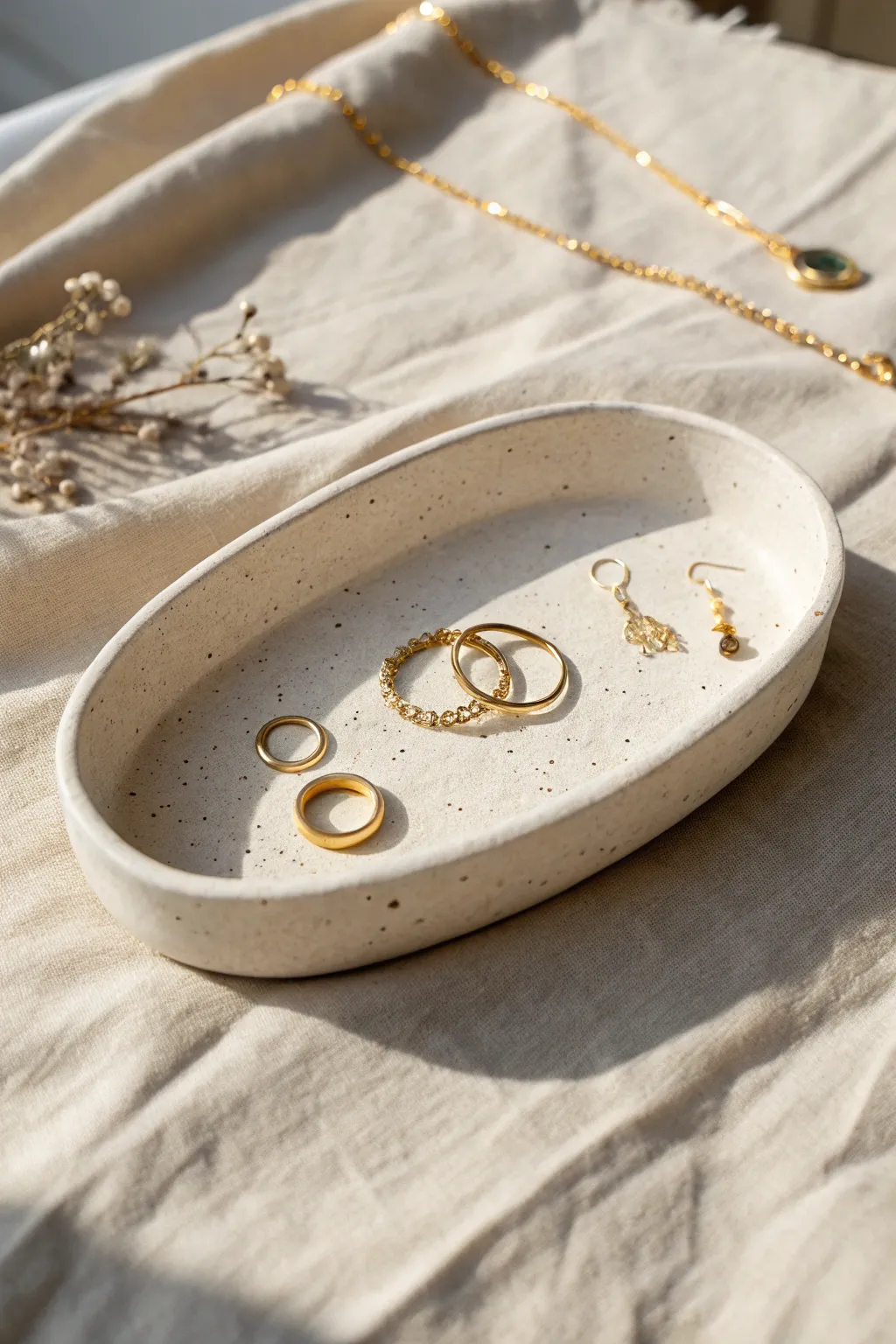 Minimal oval clay tray dish with rings and studs, Scandinavian calm with a soft boho touch.