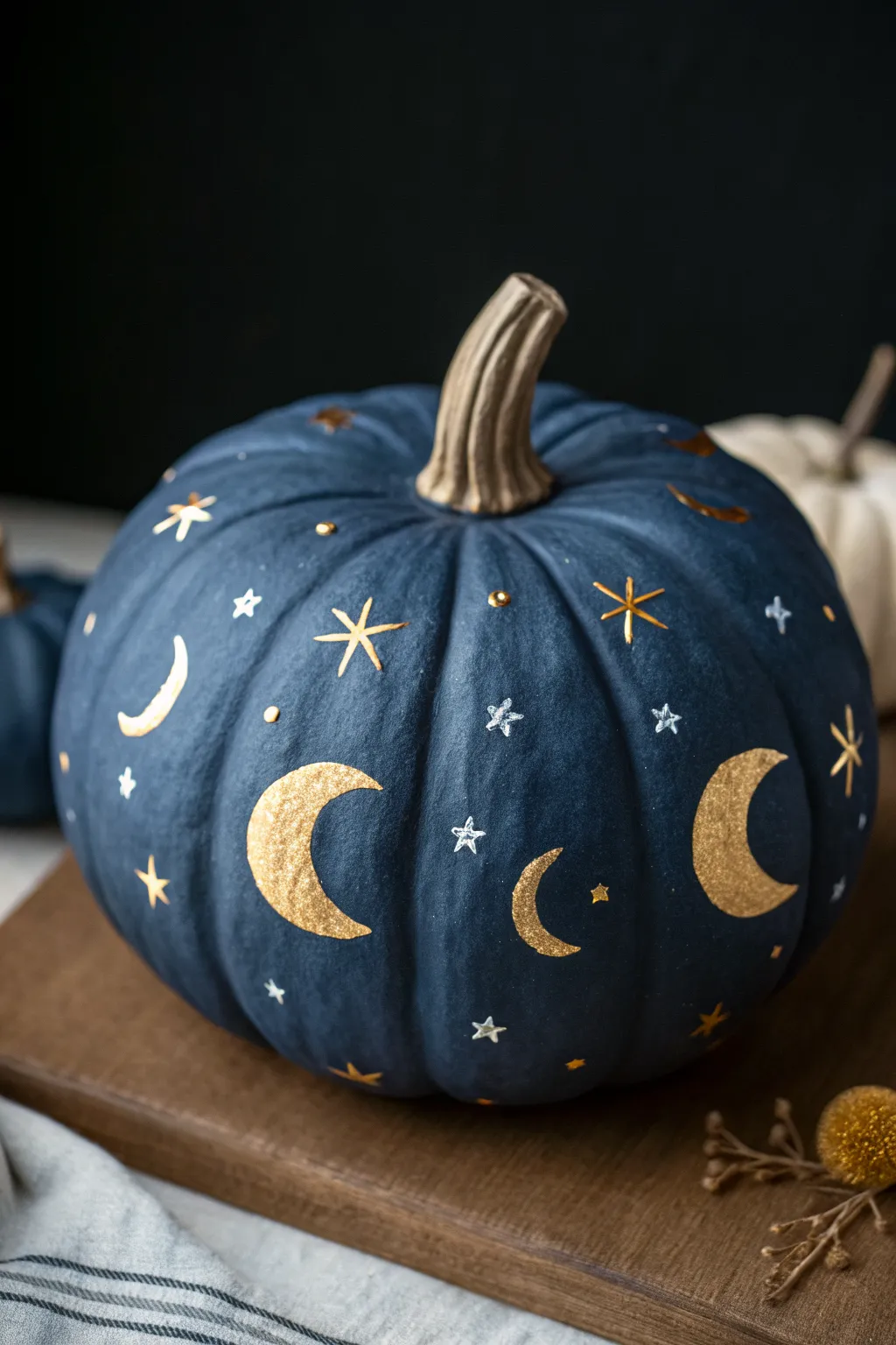 Navy clay pumpkin with gold moons and stars for an elegant, night-sky Halloween look