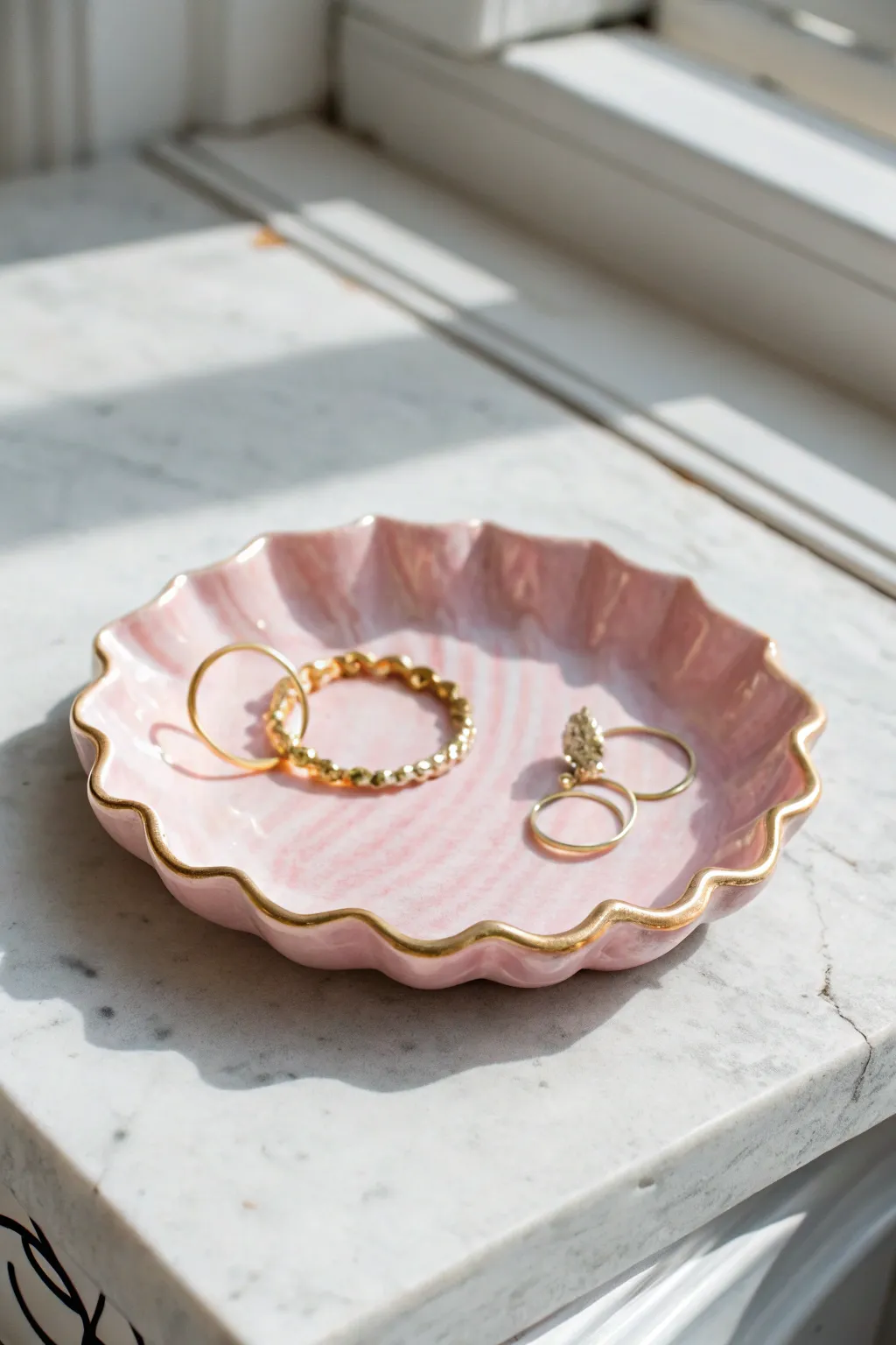 Soft pastel scalloped jewelry tray on pale stone, a minimal boho accent for earrings and bracelets.