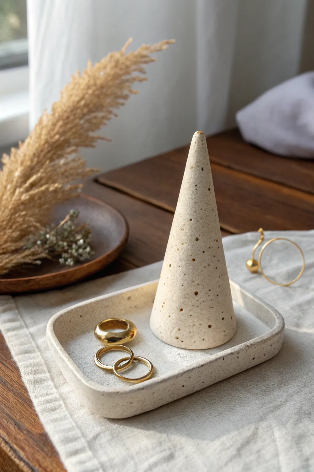 Minimal clay ring cone and jewelry tray with soft satin texture for a calm boho vanity.