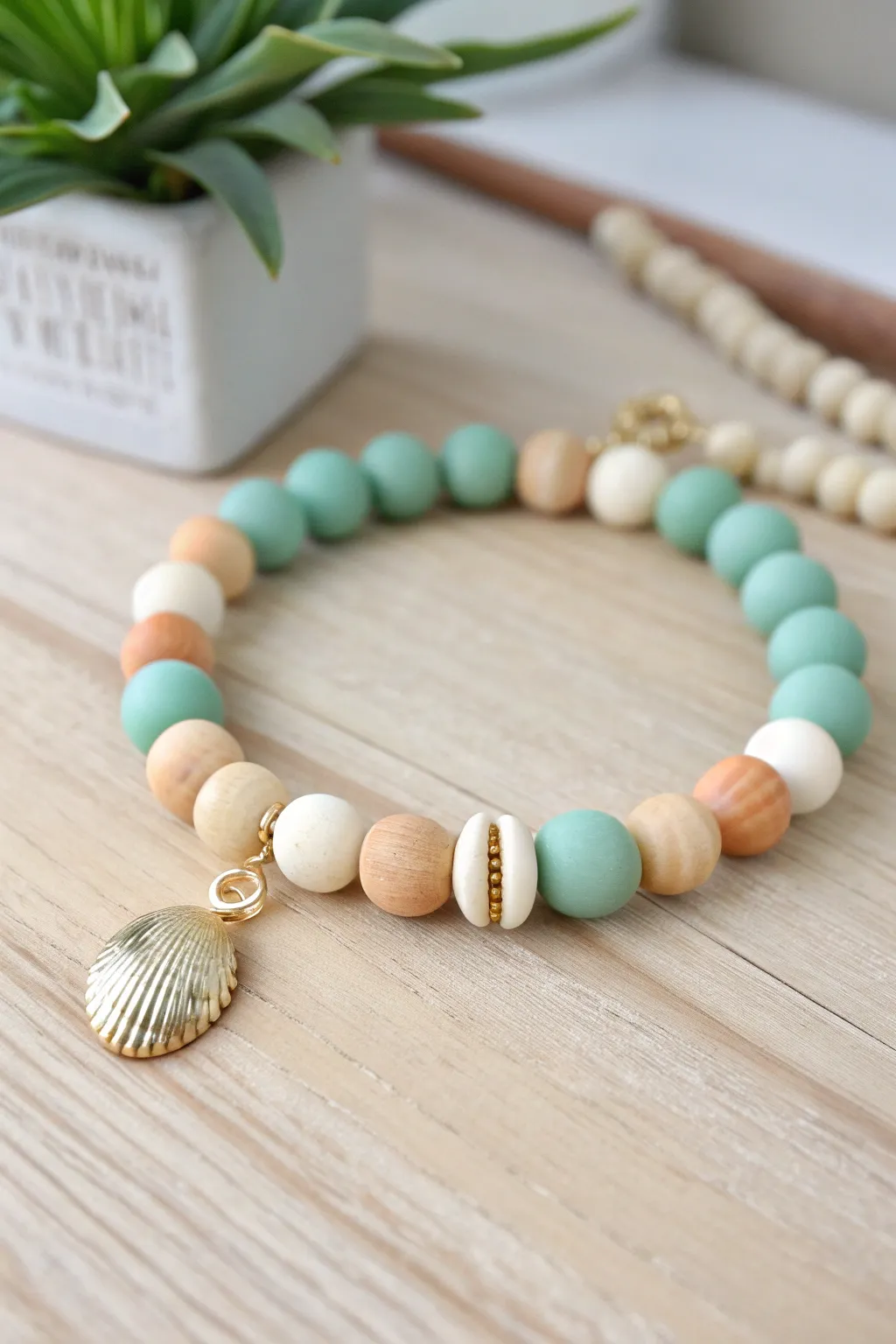 Seafoam clay beads and a simple shell charm for an easy, beachy bracelet to DIY at home.