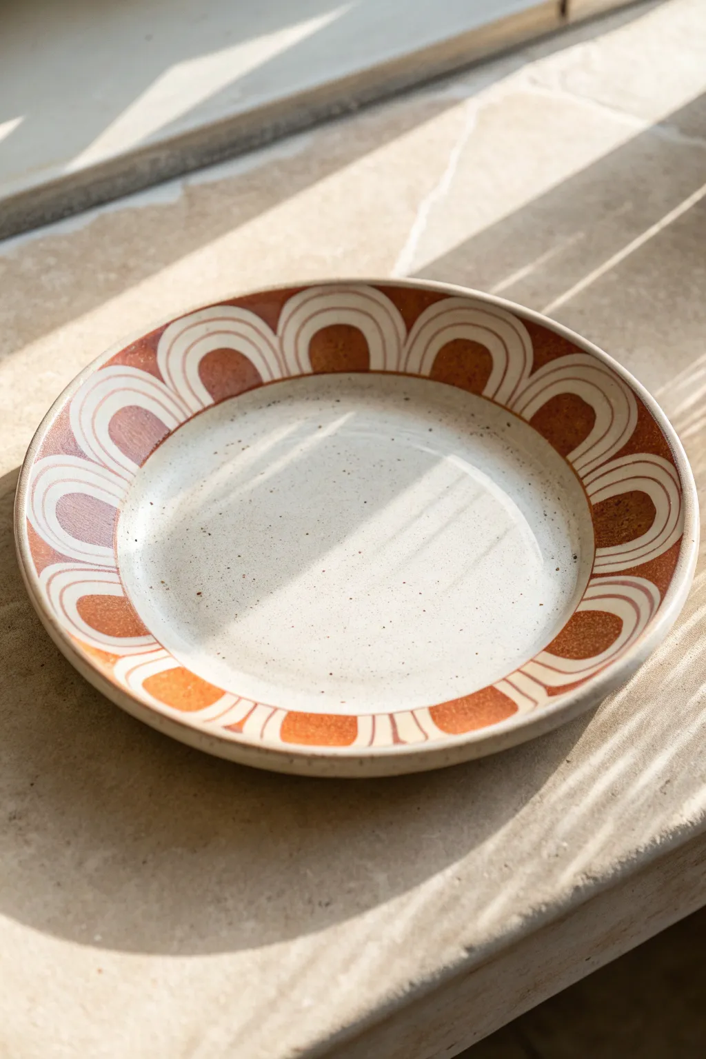 Chunky negative-space arches on the rim for a modern, beginner-friendly ceramic plate design.