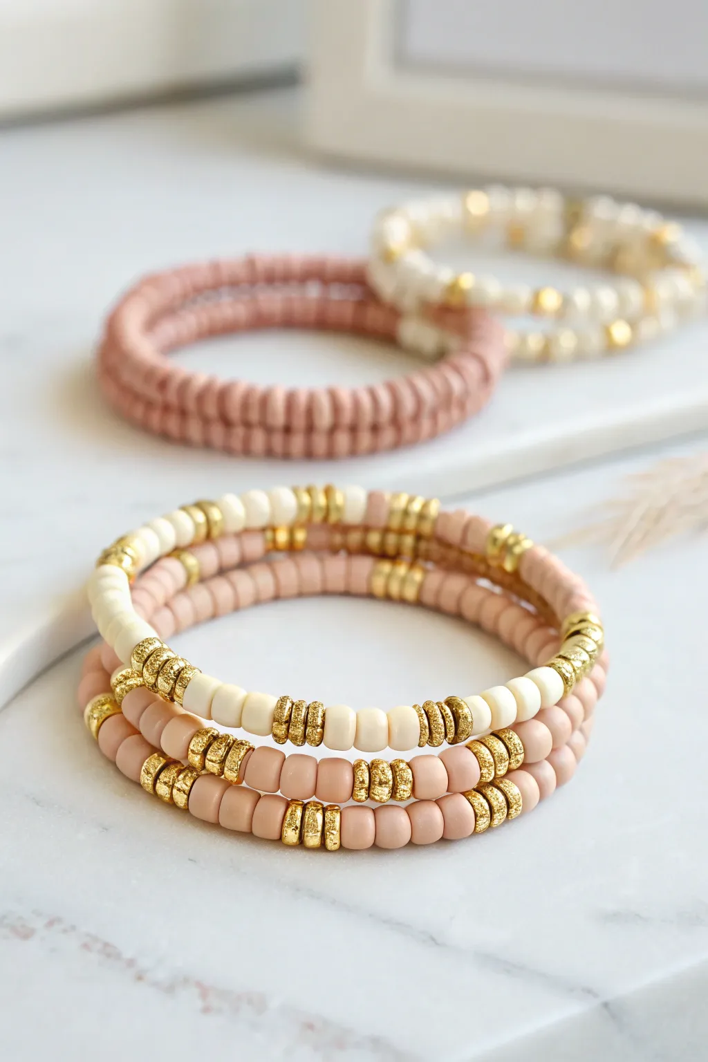 Cute clay heishi bracelet with repeating gold spacers, styled in a soft minimalist stack.