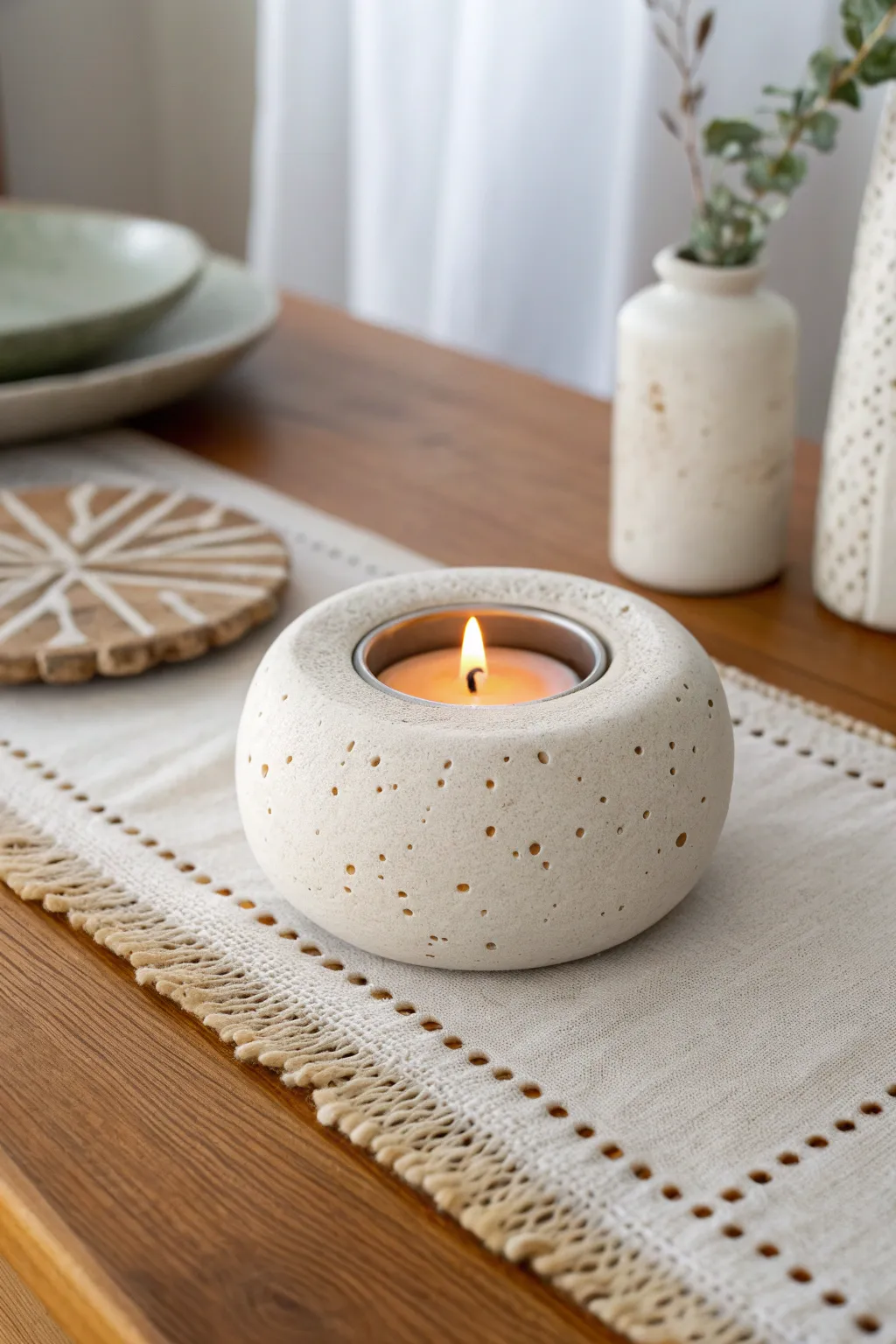 Simple handmade clay tea light holder with soft glow, minimal dots, and cozy Scandi warmth