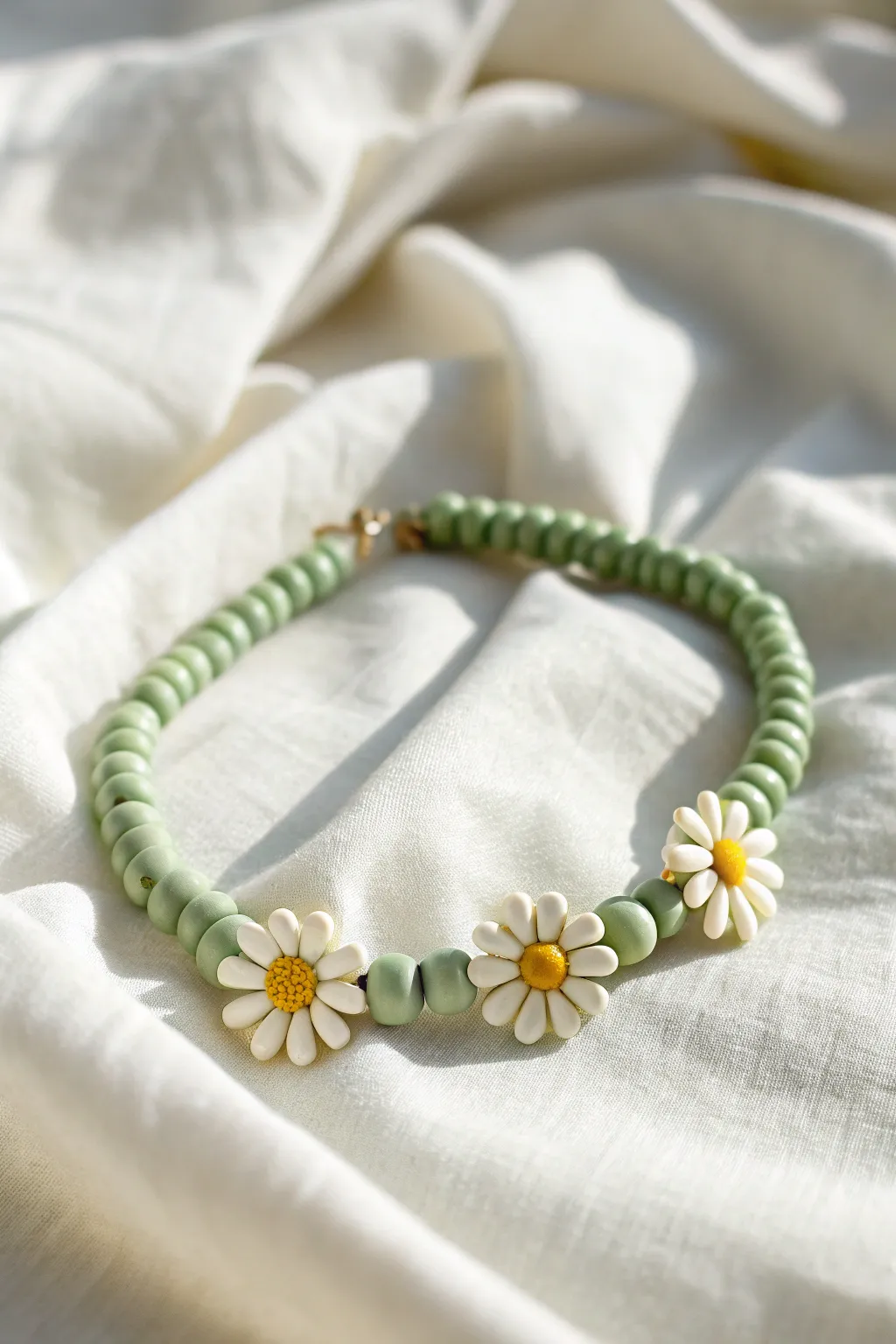 Sage green heishi bracelet with sweet daisy clay accents, minimal and softly boho.