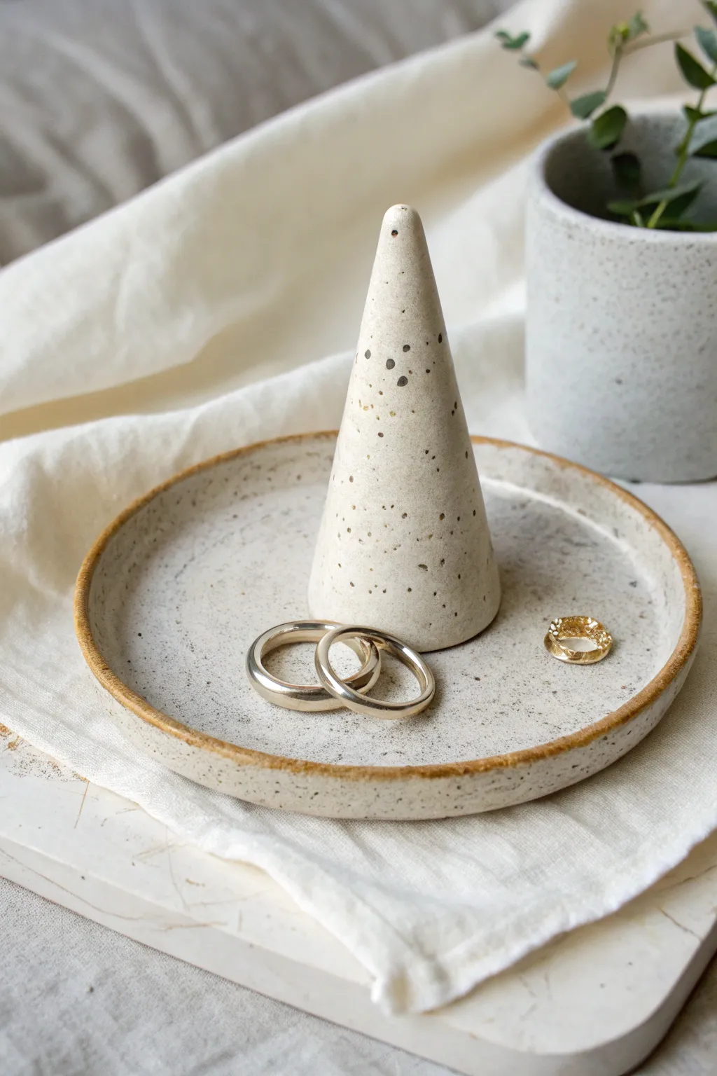 Handbuilt ring cone and slab tray set in soft speckled glaze, styled with minimal rings.