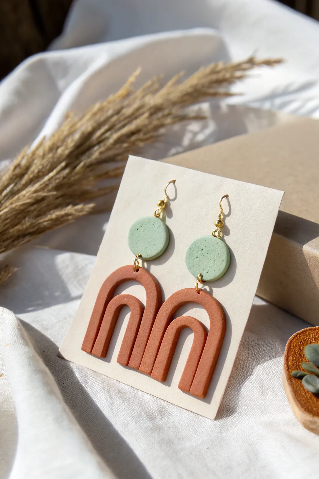 Simple clay arch and circle earrings in earthy tones, styled minimal for modern boho charm.