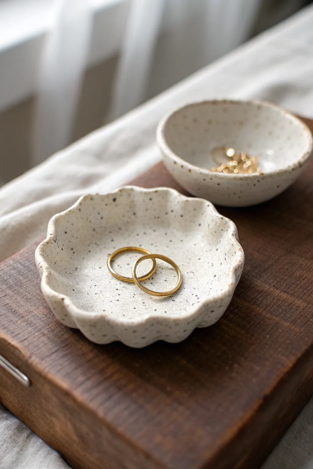 Tiny scalloped clay trinket dish that keeps rings safe and looks chic on any nightstand.