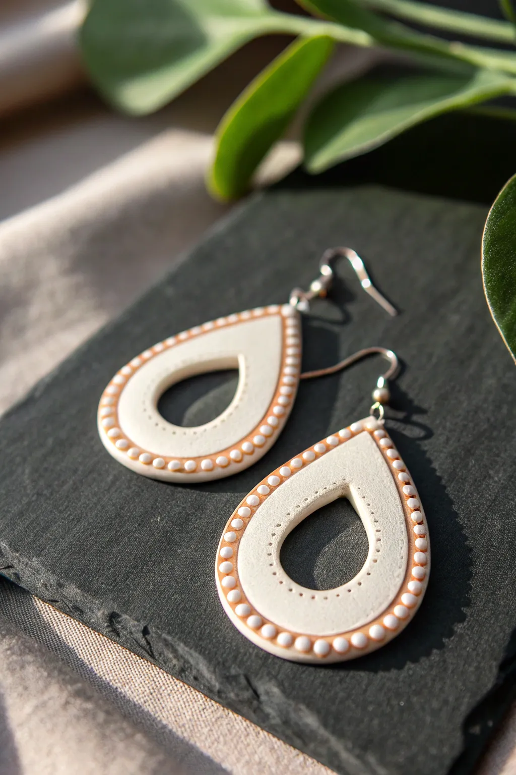 Geometric clay drop earring with a fine extruded frame outlining a clean cutout center