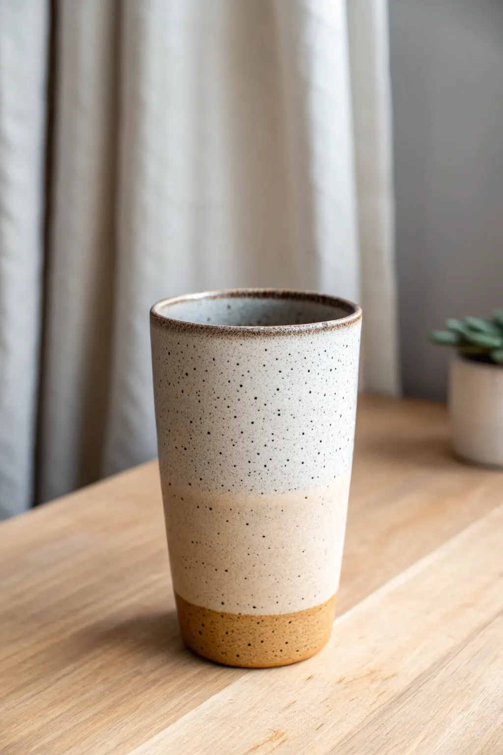Stippled ombré glaze that fades from charcoal to sand, adding depth to a minimalist cup.