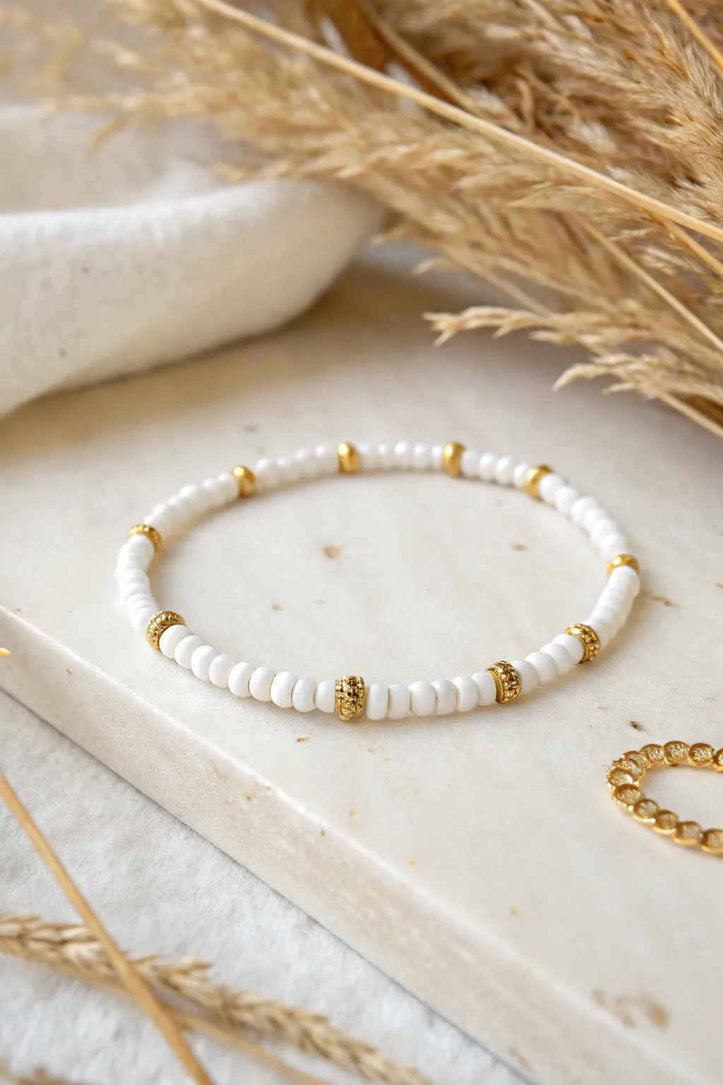 All-white heishi bracelet with gleaming gold spacers for a crisp, preppy minimalist look.