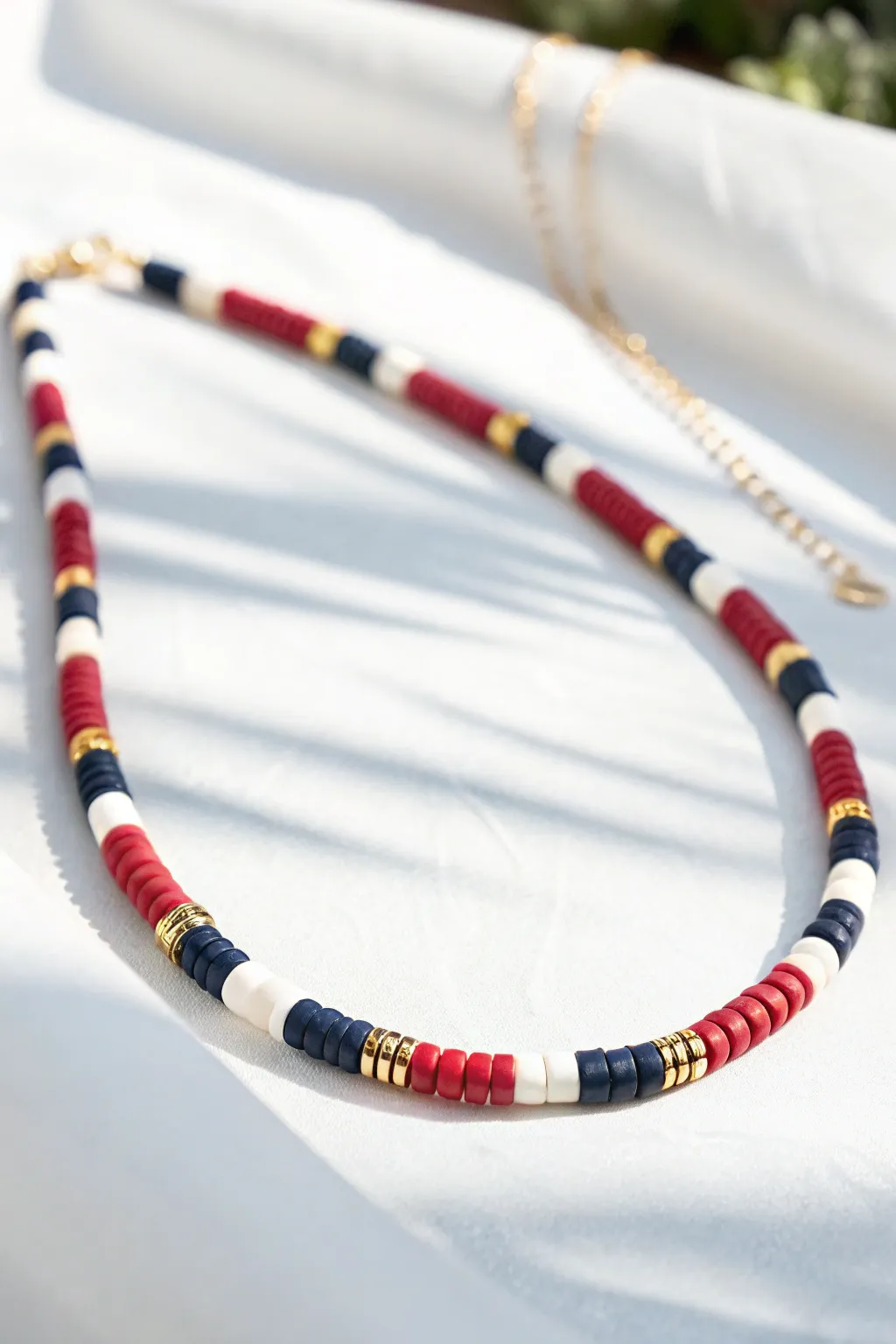 Varsity stripe color blocks in navy, white, and red for a clean preppy heishi look.