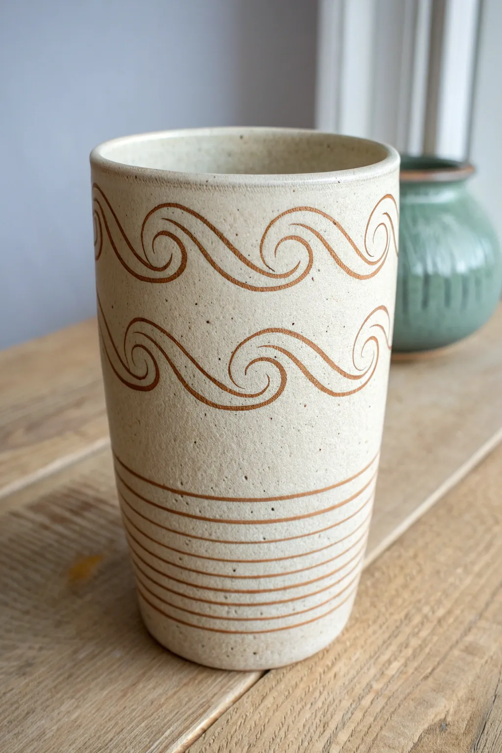 Minimal sgraffito wave cup with flowing curves and delicate ripples for an ocean-inspired look