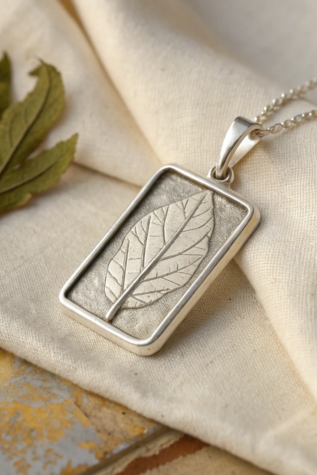 Minimal silver clay specimen frame pendant with botanical texture and a clean blank label panel