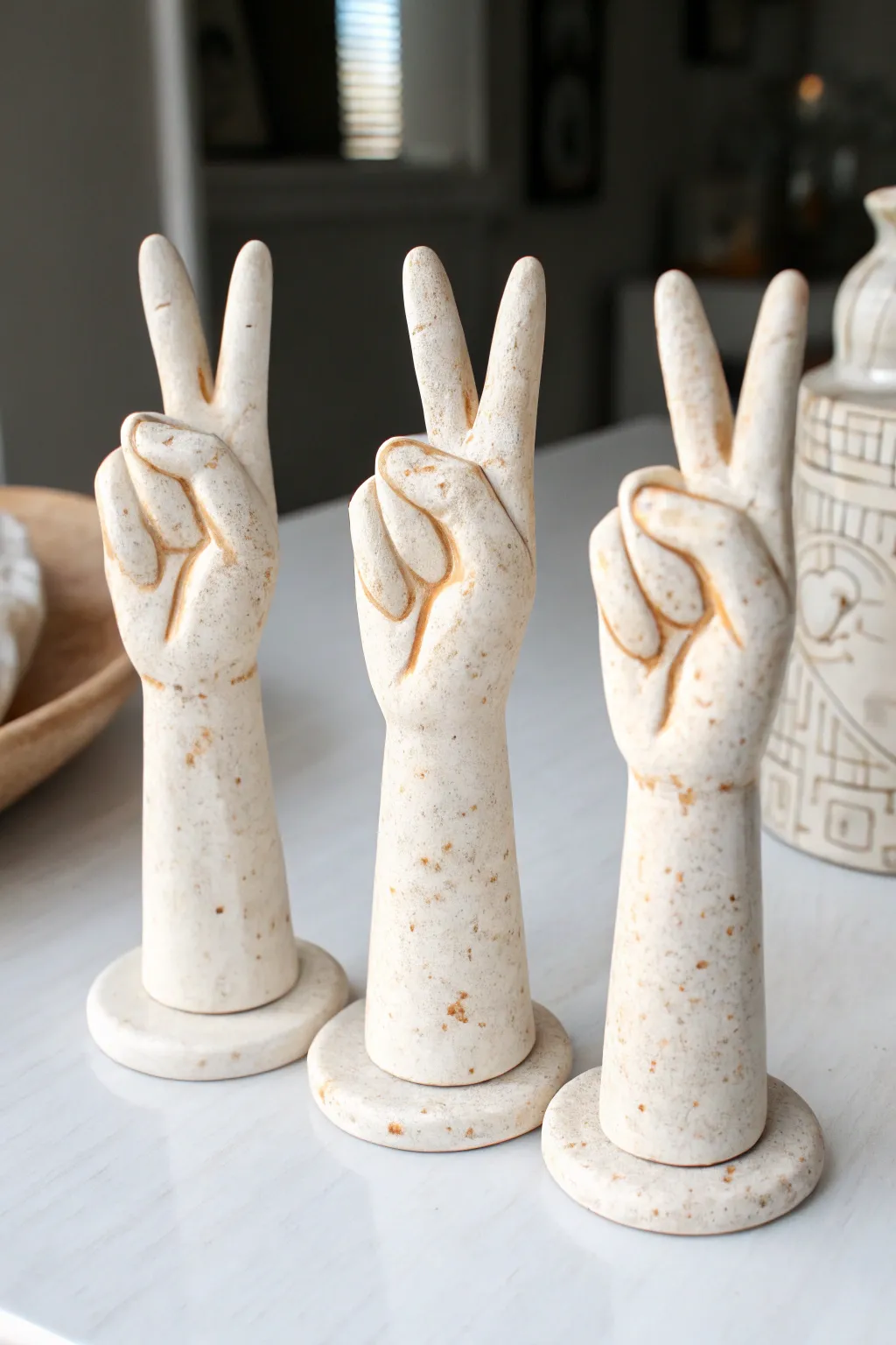 Mini clay hand gestures in minimalist style: peace, wave, and heart with crisp shadows.