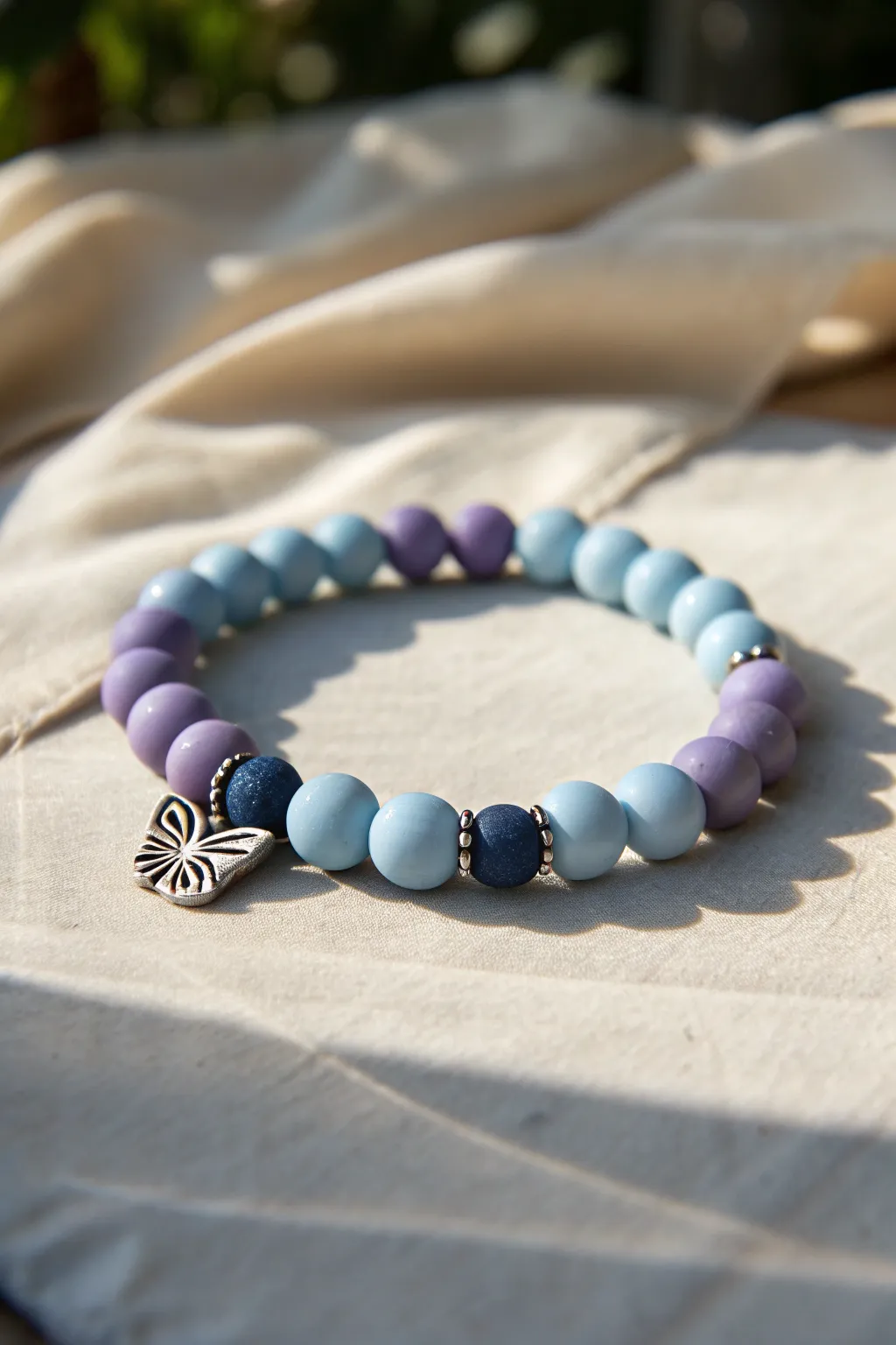 Butterfly-inspired clay bead bracelet in lilac and sky blue with deep navy accents