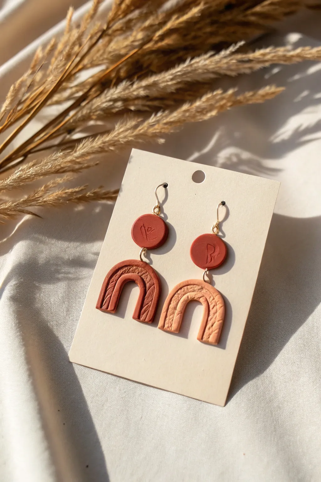 Sculpted mismatched clay earrings with circle and arch shapes, minimal boho elegance.